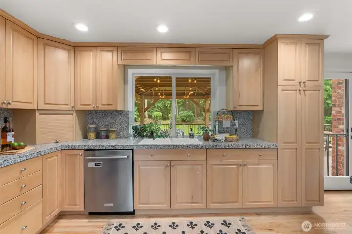 The full, chef's kitchen offers stainless, modern appliances, and light oak cabinetry.