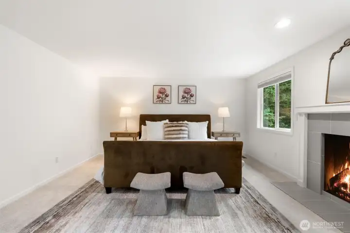 The spacious, relaxing primary bedroom suite features a cozy gas fireplace for added comfort.