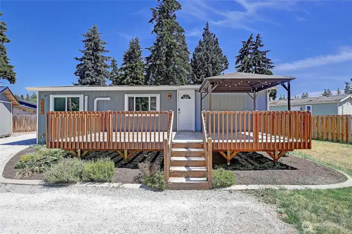 Enjoy outdoor living on the expansive front deck featuring a covered gathering area.