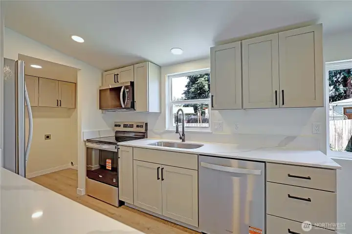 Beautifully remodeled kitchen featuring new shaker cabinets, quartz countertops, and stainless steel appliances.