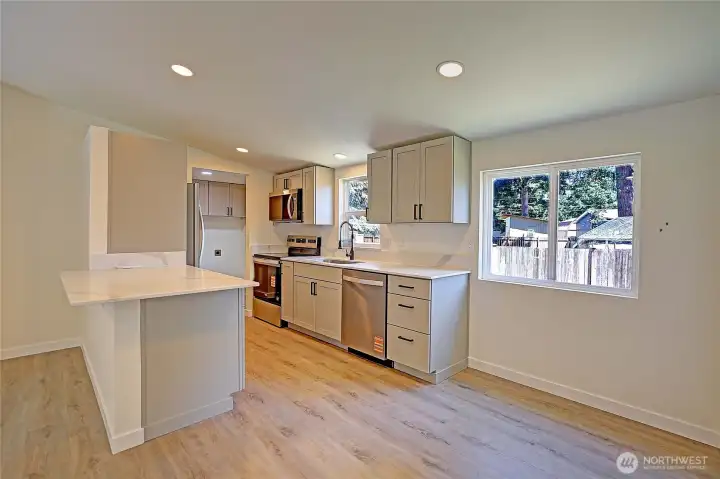 Beautifully remodeled kitchen featuring new shaker cabinets, quartz countertops, and stainless steel appliances.
