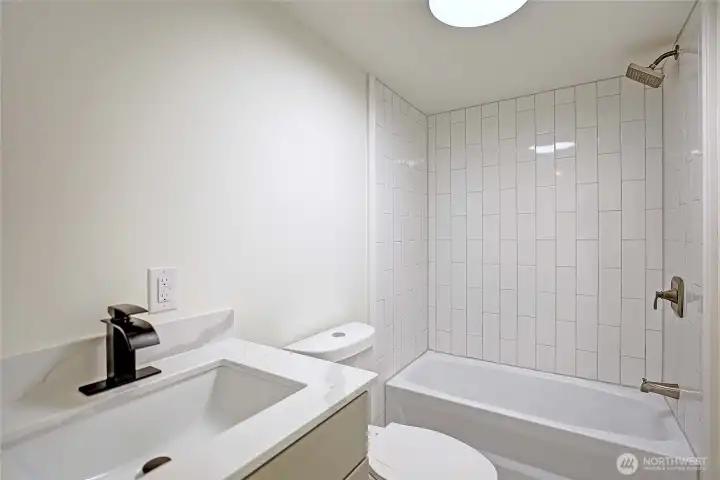 Remodeled guest bath with custom tile and quartz vanity.
