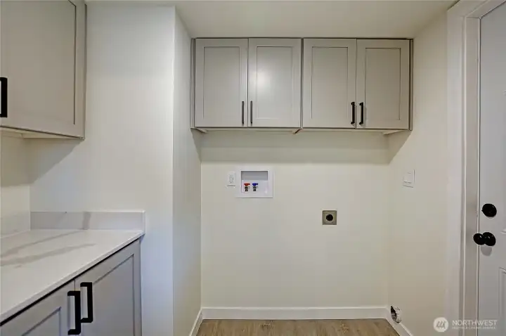 Spacious utility room offers extra storage, folding space, and room for a full-size washer and dryer.