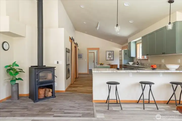 Greatroom living with wood stove and breakfast bar. Greatroom living with wood stove and breakfast bar.