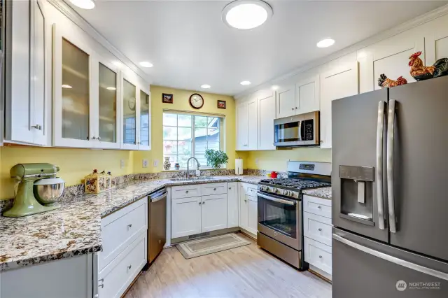 Beautifully remodeled kitchen with custom cabinets, granite counters, newer Stainless Steel appliances, and solar tube for additional lighting. Luxury vinyl plank flooring throughout.