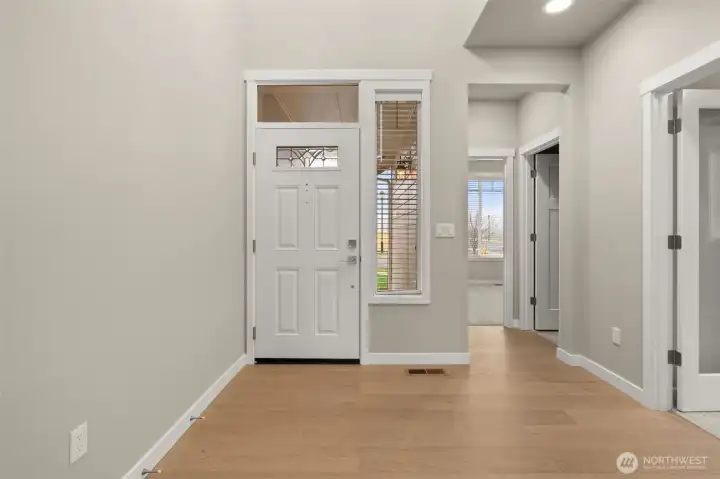 Entryway looking back at entry door with decorative glass panels that allow natural light to shine through!