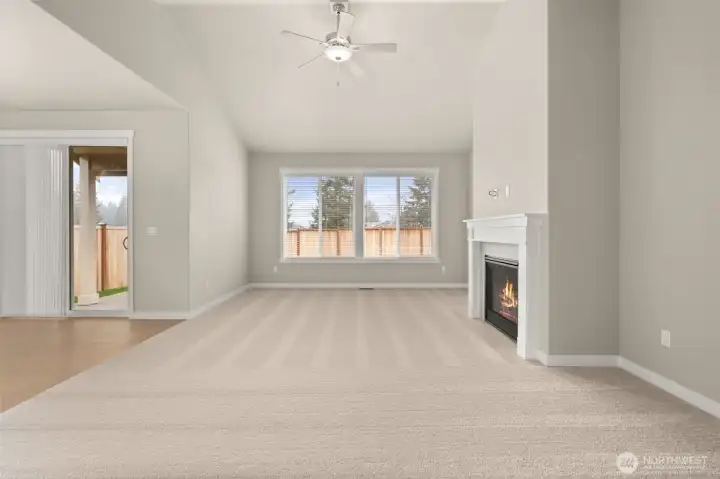 9’ ceilings and wood wrapped windows on main floor. Living room with plenty of natural light featuring cozy gas fireplace with tile surround and ceiling fan.