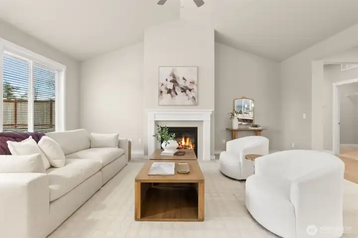 Living room with plenty of natural light featuring cozy gas fireplace with tile surround and ceiling fan.