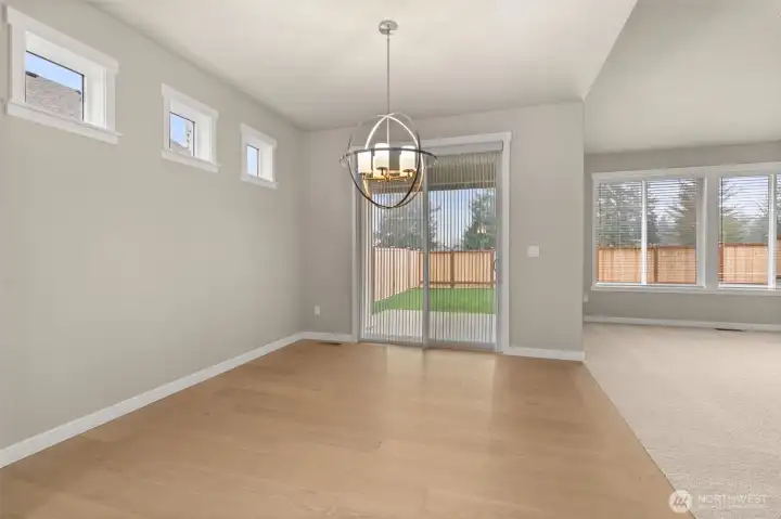 Dining area features hardwood flooring and a glass slider that opens to backyard and patio area.