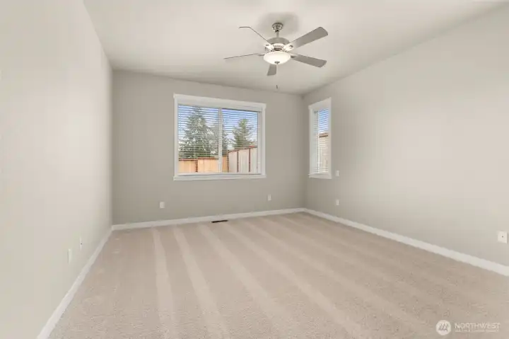 Inviting and spacious primary bedroom with ceiling fan for added comfort.
