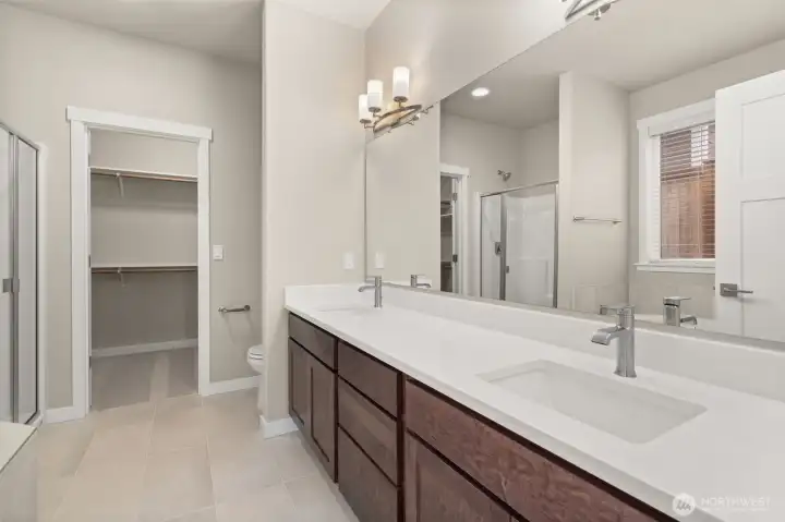 Primary bathroom comes with a standard separate walk-in shower with glass door, double vanity with undermount dual sinks, tile floor, quartz countertops.