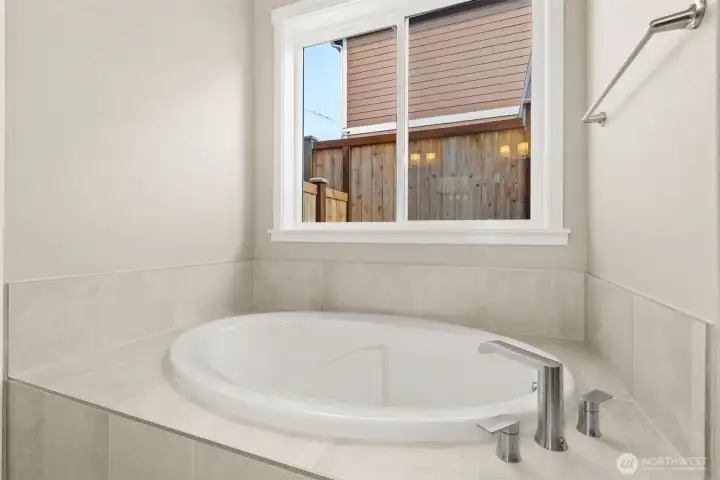 Soaking tub with tile surround.