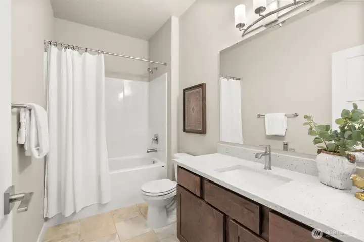 Full bathroom with undermount sink in Sable-stained Maple cabinet, quartz countertop with backsplash and tub/shower.