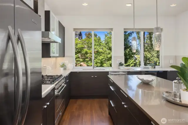 Kitchen sink framed by large windows and ample counter space.