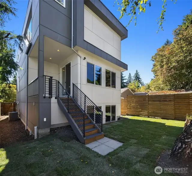 Fully fenced yard featuring covered deck off of kitchen.