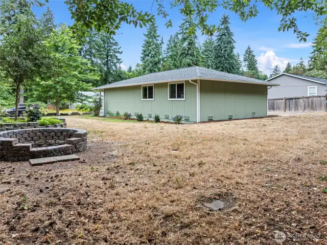 Spacious, nearly half-acre flat lot with room for RV parking, gardening, and entertaining around the fire pit.
