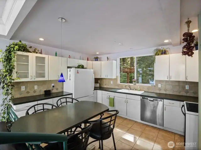 Large kitchen features built in table. There is almost always hummingbirds outside the window!