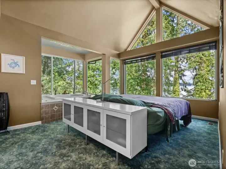 Large primary suite features vaulted ceiling and incredible view. It feels like you’re in a treehouse!