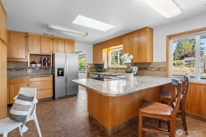 A stylish eat-in kitchen with stainless steel appliances, granite counters and breakfast bar.