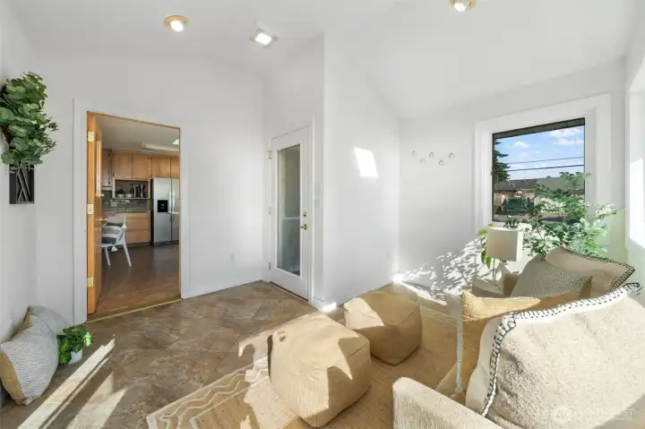 Sunroom with access to front yard, private deck and kitchen.