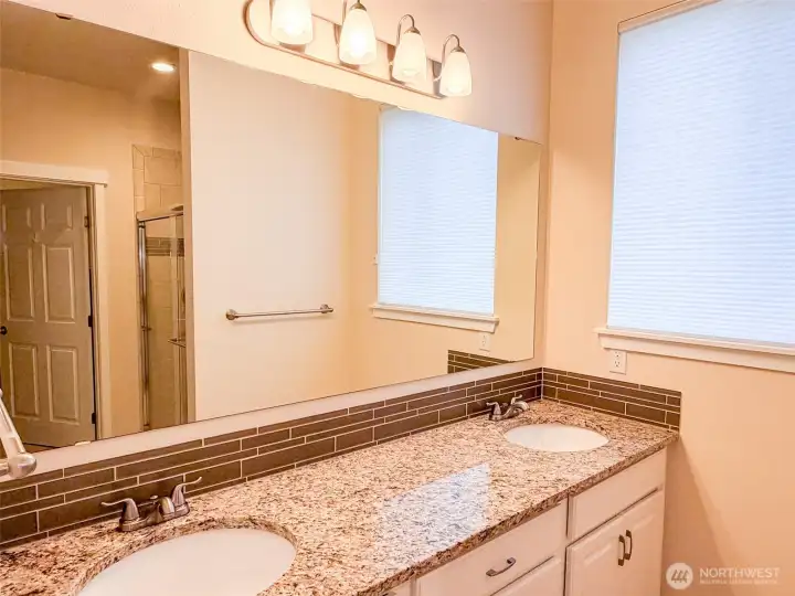 Double vanity, walk-in closet and walk-in shower in primary bath.