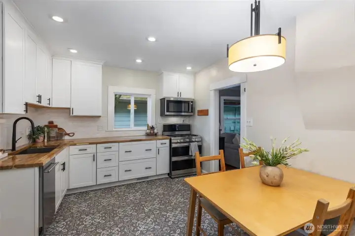 The remodeled kitchen has Spanish tile floors, butcher block counters, new cabinetry and new dishwasher