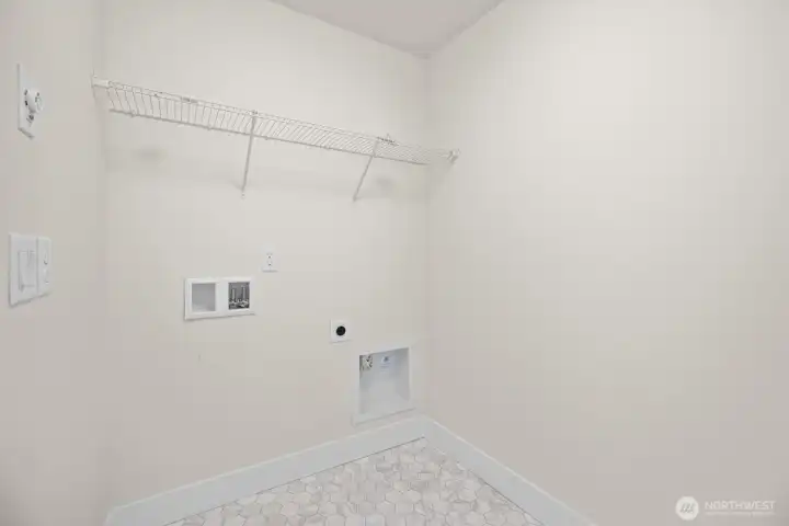 The utility room is located on the upper level between the bedrooms.