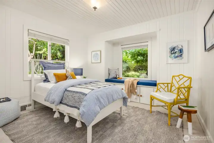 Bright secondary bedroom with abundant natural light and charming window seating.