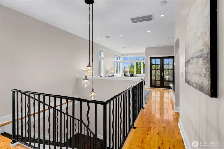 An elegant chandelier highlights the stunning wrought-iron railing, adding sophistication to the space