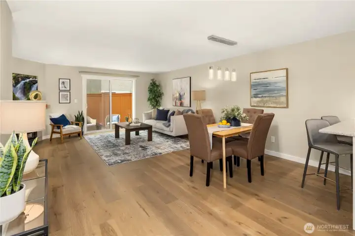 Relax or entertain in this welcoming open-concept living area and dining space that seamlessly transitions to the outdoors via sliding glass doors. Hardwood flooring, fresh paint, and modern lighting provide an upscale feel.