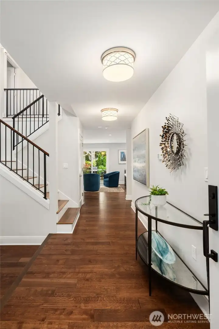 Upon entry you are greeted with gleaming hardwood floors, an open stairway and custom lighting fixtures.