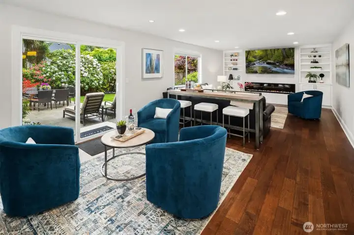 Looking from the kitchen to the casual sitting area, Bar Table and TV area.  You catch a glimpse of the open backyard area through the slider door.