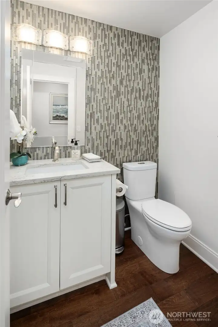 The power room on the main floor with Custom cabinet , quartz counter, undermount sink, comfort height toiler and custom glass wall.