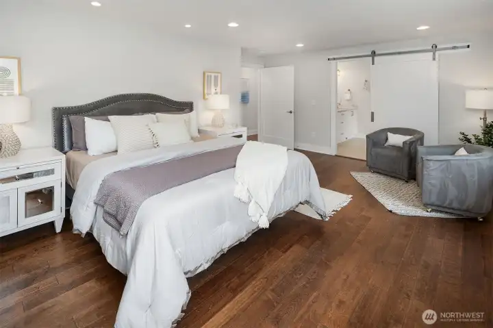 The Primary Bedroom looking from the Nrothwest corner toward the bathroom with Barn Door.