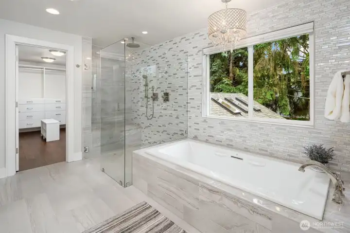 A view of the Primary Bathroom Tub and shower looking through to the Walk-in Closet.