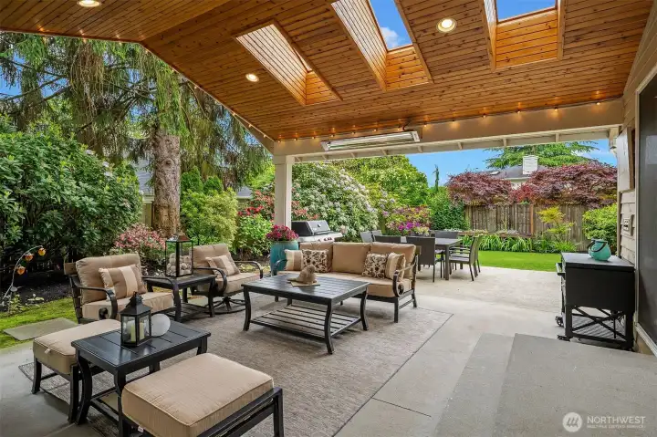 Looking from the outdoor room to the uncovered patio and grass area.