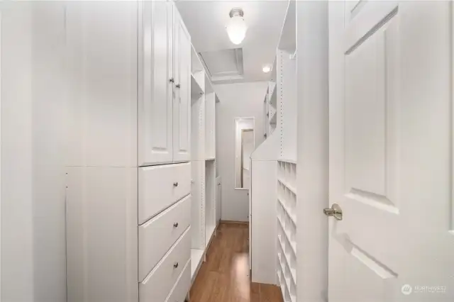 Very well organized primary closet with custom cabinets, soft close drawers and clothes hamper.