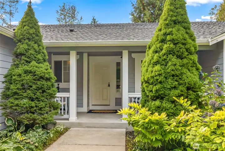 Walk up to this porch surrounded by established landscaping