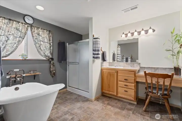 Luxurious primary bathroom with walk-in shower, separate soaking tub, and make-up counter.