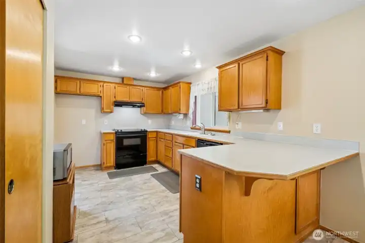 Large kitchen with a breakfast bar. Pantry door on the left.
