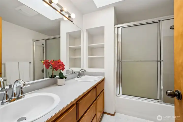 Spacious hallway bathroom on the 2nd level with new sinks and fixtures, built-in shelves. Skylight makes the room bright.