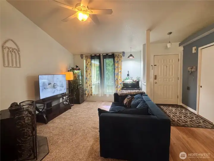 The living room features a wood pellet stove. It has a vaulted ceiling, and a ceiling fan.