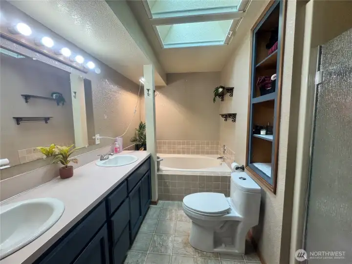 The primary bathroom features a double vanity, large soaking tub, walk-in shower and large skylight.