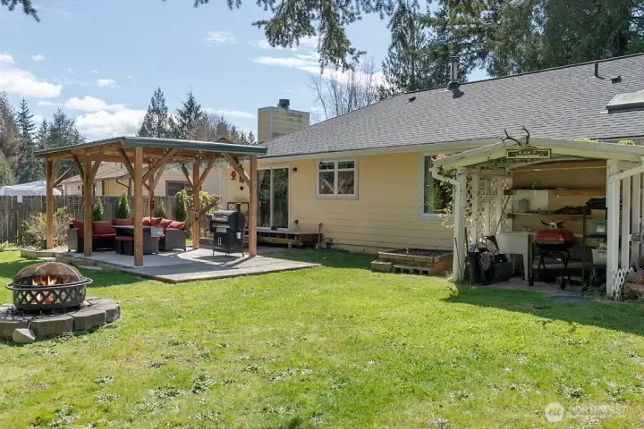 Large backyard with several multipurpose spaces, including a covered patio for year round use