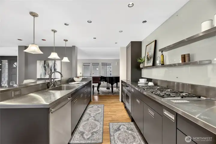 Gourmet kitchen with sleek cabinetry, stainless steel counters & gas range. Long workspace, ample storage & open flow make it ideal for cooking & entertaining.