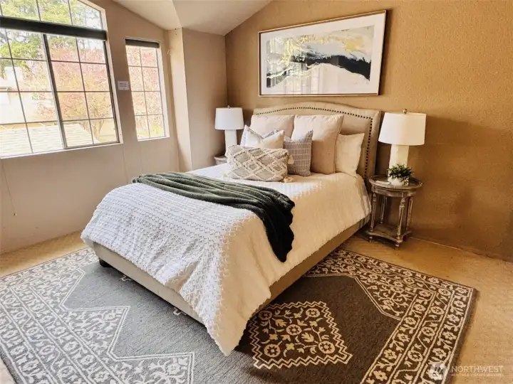 Spacious primary suite with vaulted ceilings, large windows & abundant natural light. Serene retreat with cozy sitting area & peaceful outlook.