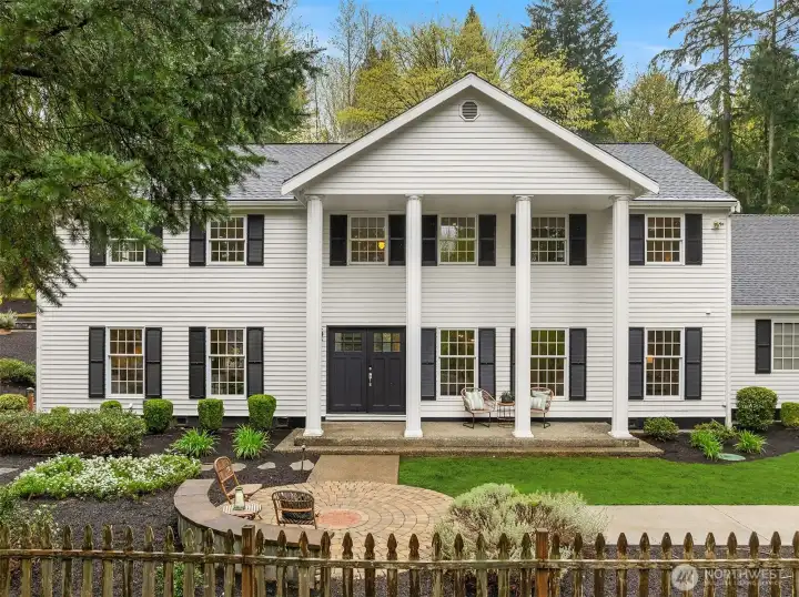 This is the address people mean when they talk about what makes Woodinville special — a nearly acre colonial estate tucked privately into the trees on Hollywood Hill, minutes from world-class tasting rooms, trails, dining, and everything the area is becoming.