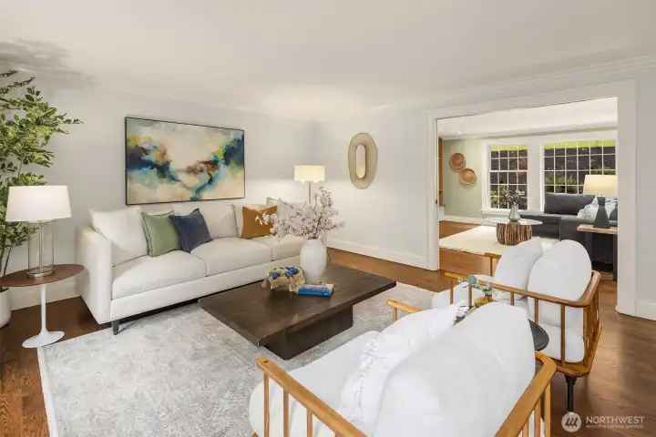 Inviting living room with crown molding, hardwood floors, abundant natural light, and open connection to the adjoining family room