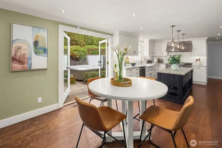 Casual dining nook with direct sight line to the hot tub and patio through French doors, open to the fully updated kitchen beyond