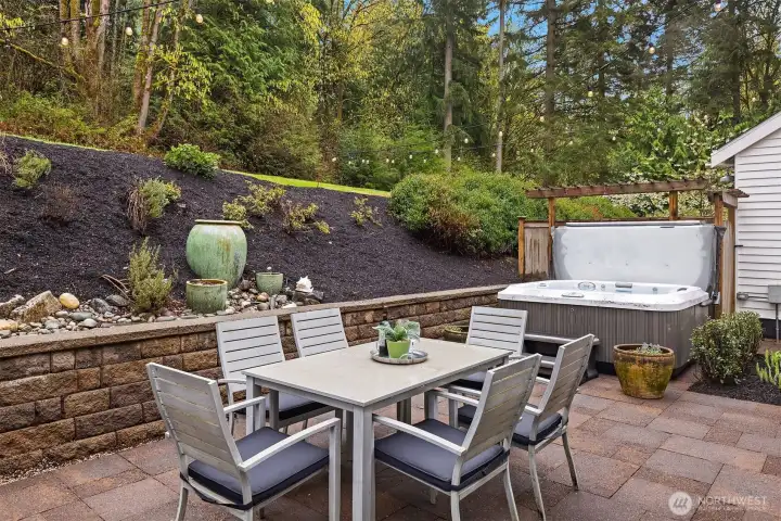 Dinner outside, a favorite local bottle on the table, and the hot tub waiting when the plates are cleared — this is what the Woodinville lifestyle actually looks like from your own backyard.